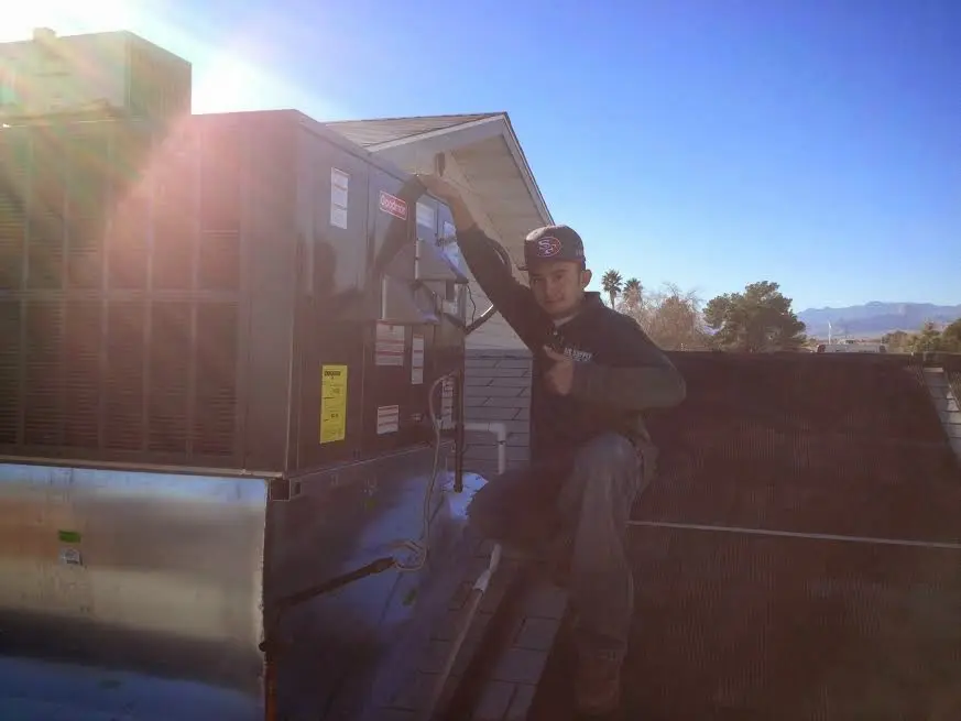 HVAC technician performing AC Tune-Up on a rooftop unit in Jefferson